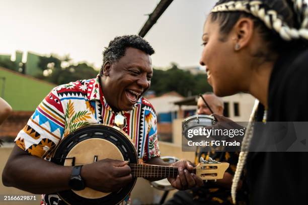 friends singing and playing instruments during party at rooftop - samba dancing stock pictures, royalty-free photos & images