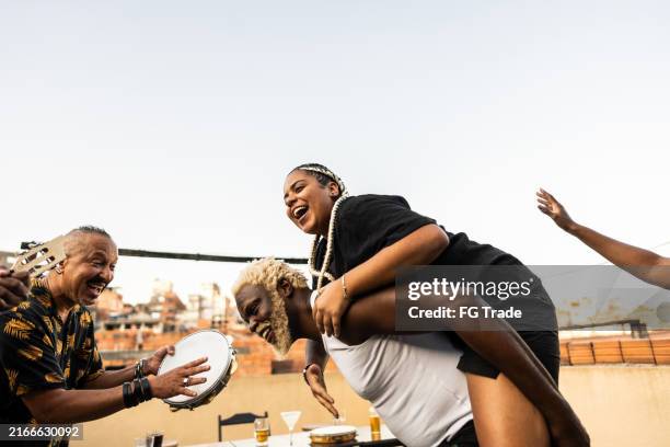 friends having fun on rooftop party - tambourine player stock pictures, royalty-free photos & images