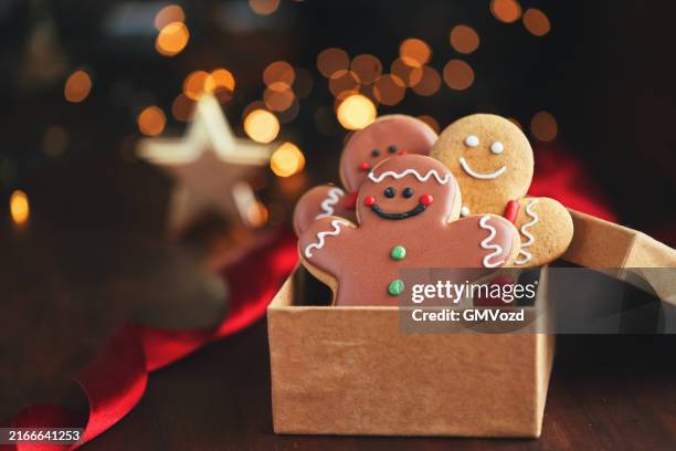 verzierte lebkuchen-weihnachtsplätzchen auf weihnachtlichem hintergrund - lebkuchengebäck stock-fotos und bilder