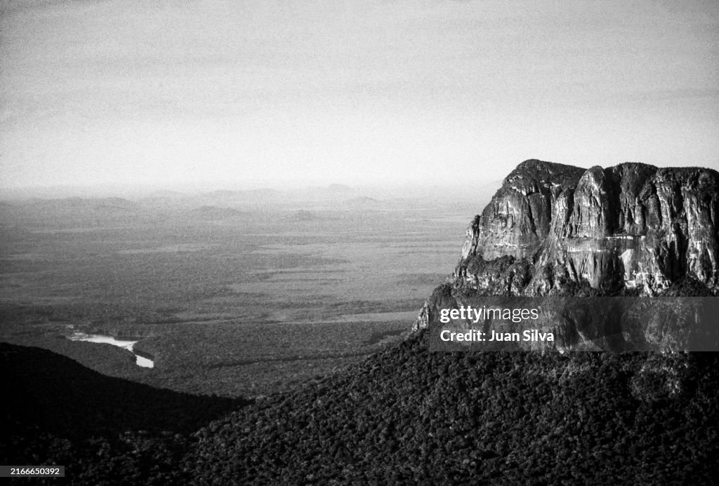 Aerial view of Wichuj and Uripicay tepuys or mountains in the middle of the Amazonas forest with rain storm at sunset, Amazonas state, Venezuela
