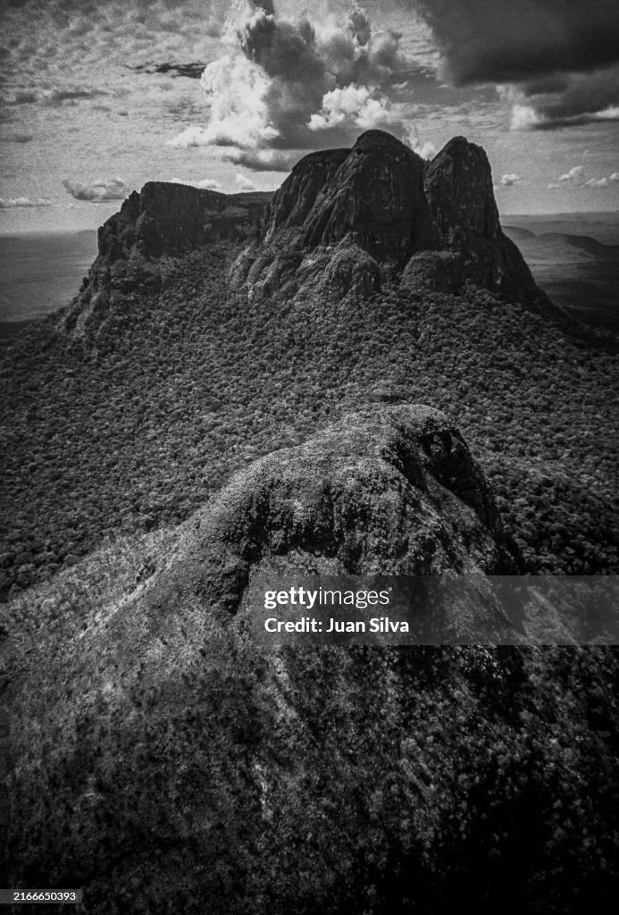 Aerial view of Wichuj and Uripicay tepuys or mountains in the middle of the Amazonas forest with rain storm at sunset, Amazonas state, Venezuela