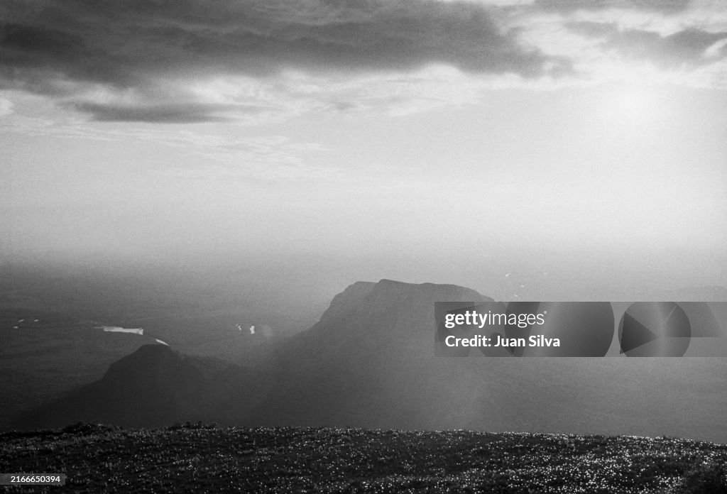 Aerial view of Wichuj and Uripicay tepuys or mountains in the middle of the Amazonas forest with rain storm at sunset, Amazonas state, Venezuela