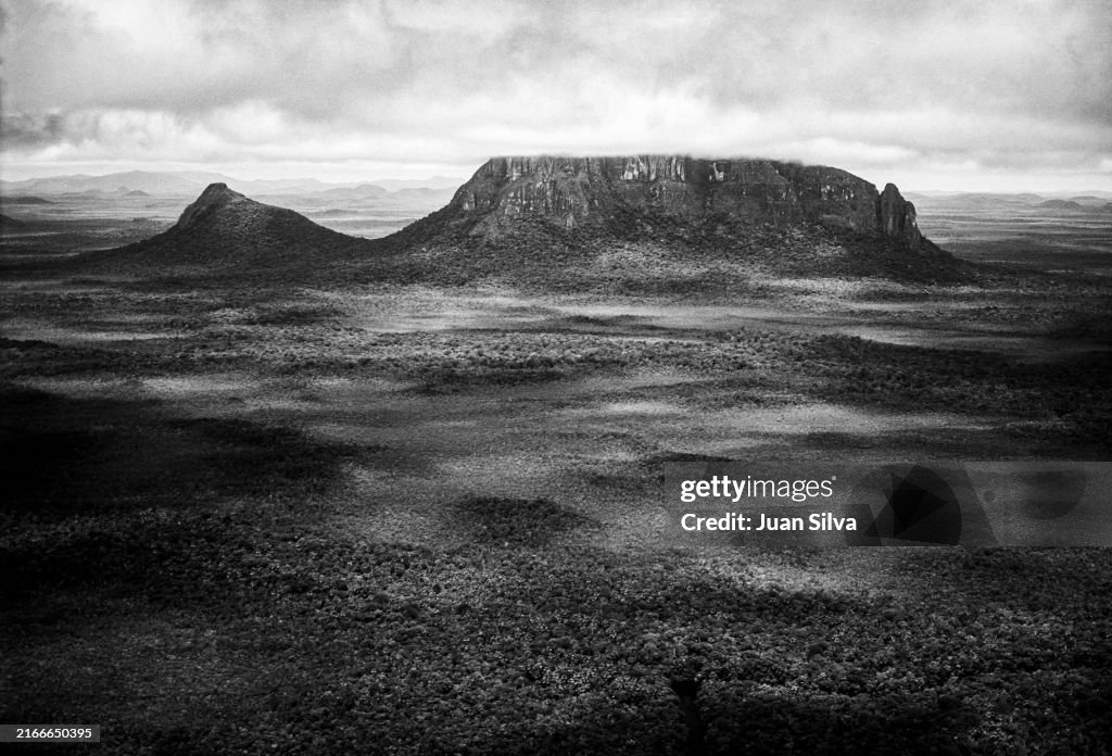 Aerial view of Wichuj and Uripicay tepuys or mountains in the middle of the Amazonas forest with rain storm at sunset, Amazonas state, Venezuela