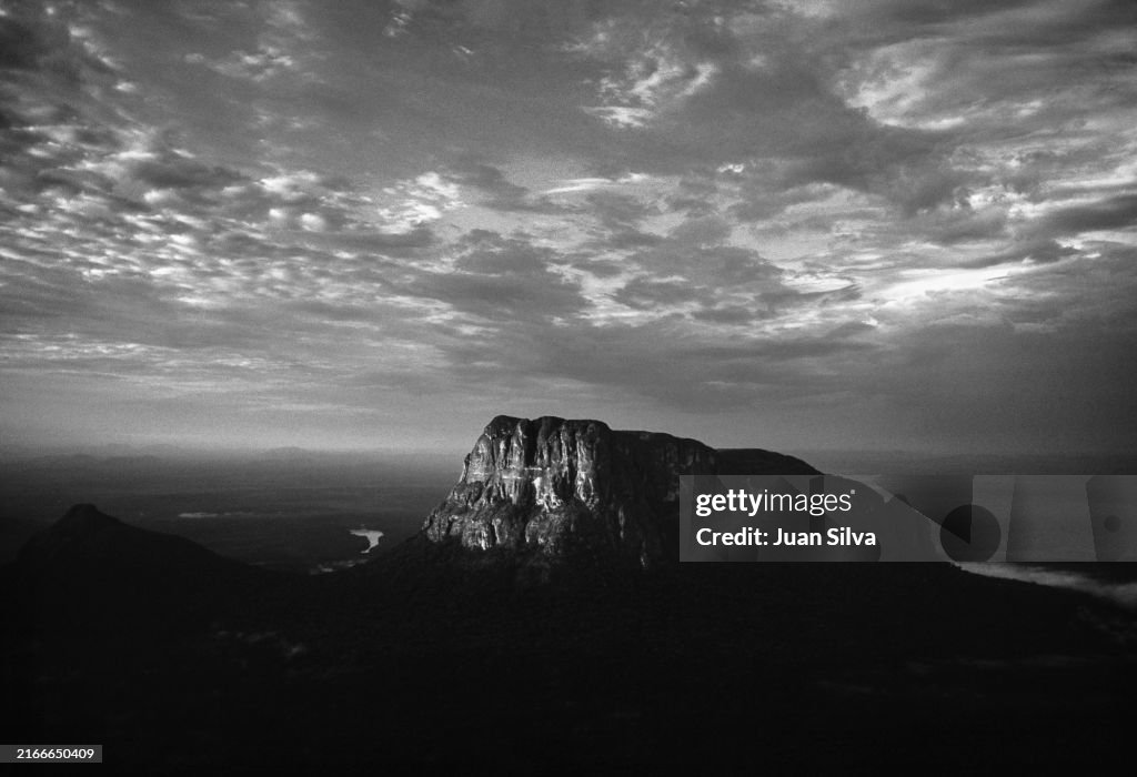 Aerial view of Wichuj and Uripicay tepuys or mountains in the middle of the Amazonas forest with rain storm at sunset, Amazonas state, Venezuela