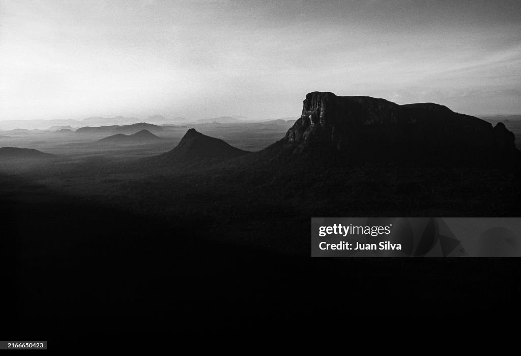 Aerial view of Wichuj and Uripicay tepuys or mountains in the middle of the Amazonas forest with rain storm at sunset, Amazonas state, Venezuela