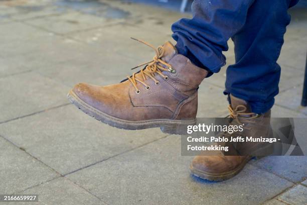 close-up of brown leather boots on pavement - arbeitsstiefel stock-fotos und bilder