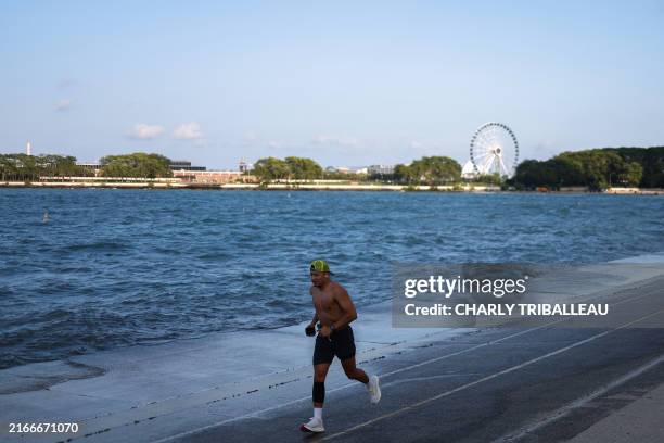 Man runs on the banks of Lake Michigan in Chicago, Illinois, on August 18, 2024.