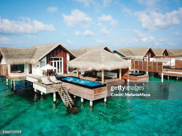 maldives water villa bungalow overwater with pool and step ladder to reach turquoise lagoon for swimming at luxury resort - bungalow stock pictures, royalty-free photos & images