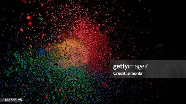 multicolored particle explosion on black background - powder paint stock pictures, royalty-free photos & images