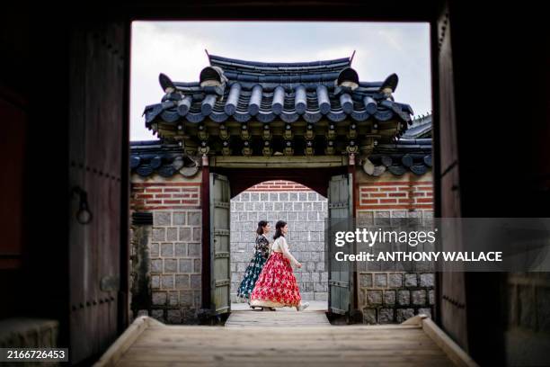Women wearing traditional hanbok dresses visit the Gyeongbokgung Palace in Seoul on August 19, 2024.