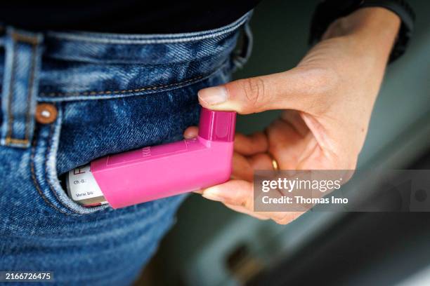 In this photo illustration a person pulls an asthma inhaler out of their pocket on August 09, 2024 in Berlin, Germany.