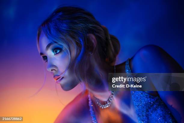 elegant woman in dramatic blue lighting - neon lighting stock pictures, royalty-free photos & images