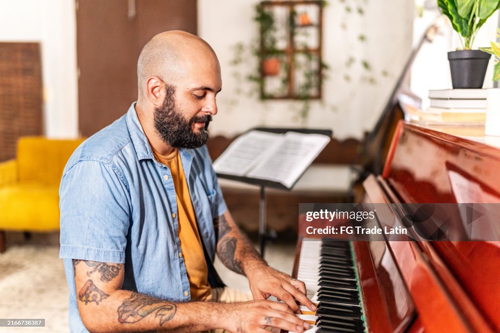 Mid adult man playing piano at home