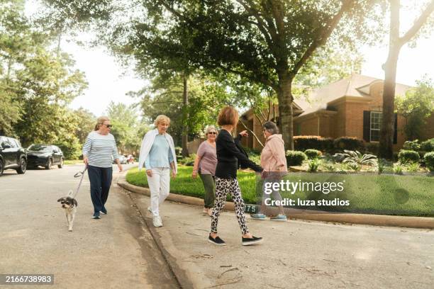 groupe de femmes âgées en promenade dans le quartier - quartier résidentiel photos et images de collection