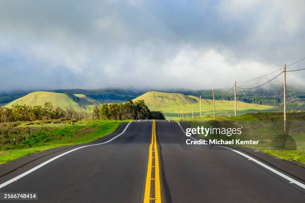 an empty road straight to the mountains - road symmetry stock pictures, royalty-free photos & images