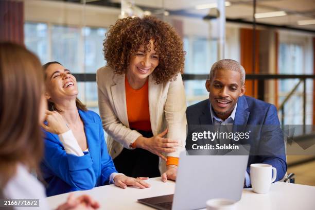 people in office enjoying teamwork. looking at laptop - scandinavie photos et images de collection
