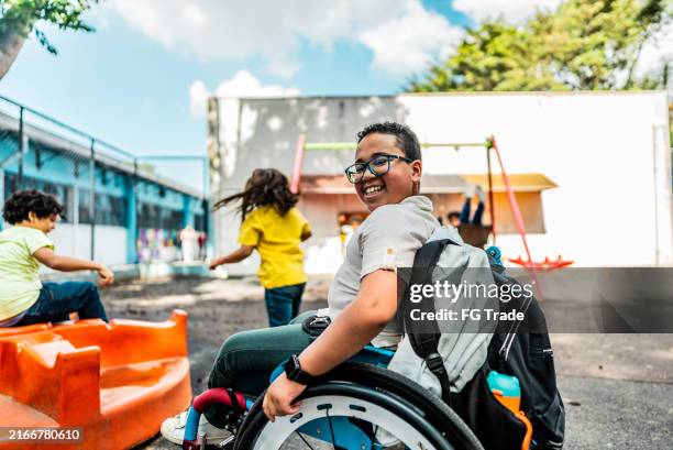 retrato de un estudiante en silla de ruedas en el patio de la escuela - acceso para sillas de ruedas fotografías e imágenes de stock