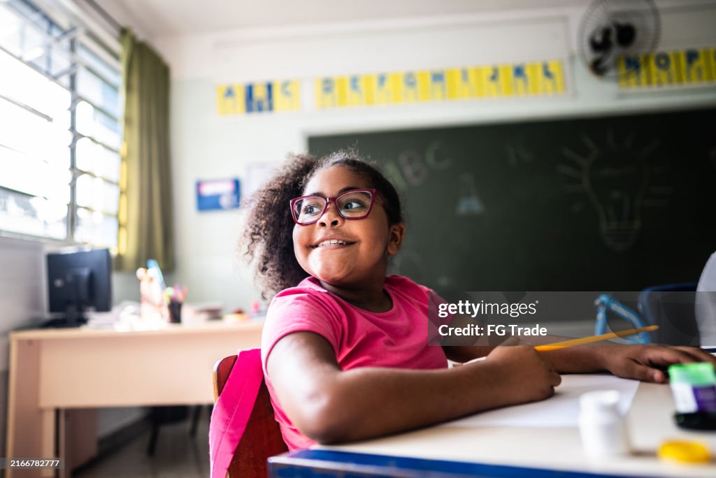 Schoolgirl contemplating on classroom at school