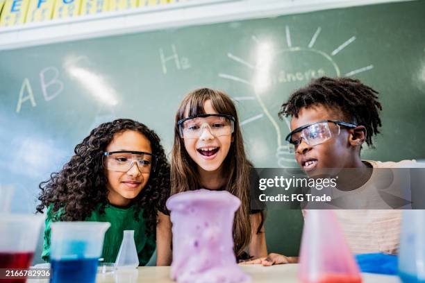 alunos fazendo um experimento em sala de aula na escola - projeto científico escolar - fotografias e filmes do acervo