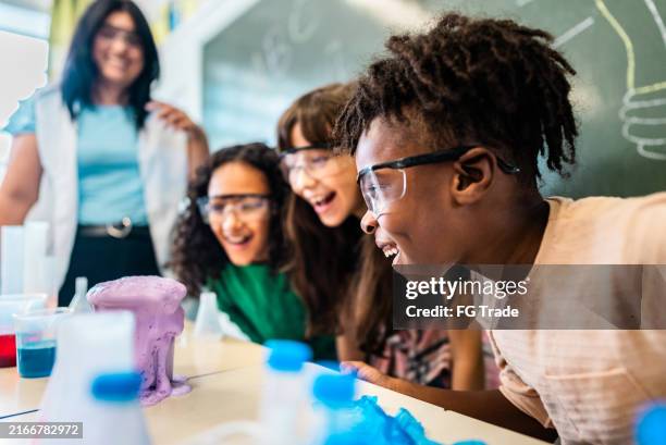 students doing an experiment on classroom on school - basisschool student stockfoto's en -beelden