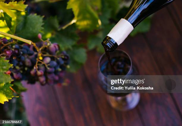 red wine being poured into a glass at a winery - maroon stock pictures, royalty-free photos & images