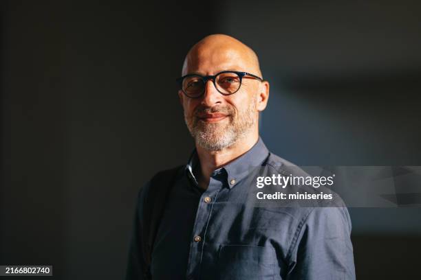 homme d’affaires confiant souriant dans un environnement urbain ensoleillé - hommes photos et images de collection