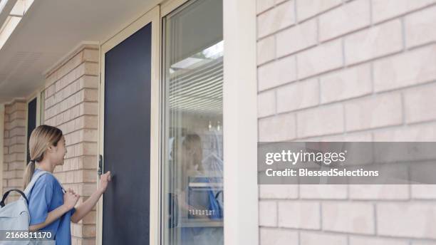 operatore sanitario asiatico che entra nella casa di un paziente anziano per una visita a domicilio - bussare foto e immagini stock