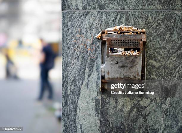 In this photo illustration a public ashtray is overflowing with cigarette butts on August 16, 2024 in Berlin, Germany.