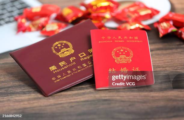An individual's household register and a marriage certificate are seen on August 15, 2024 in Shanghai, China. China's Ministry of Civil Affairs...