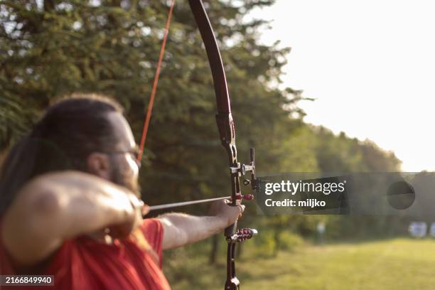 man practicing archery on the training field - archery arrow stock pictures, royalty-free photos & images