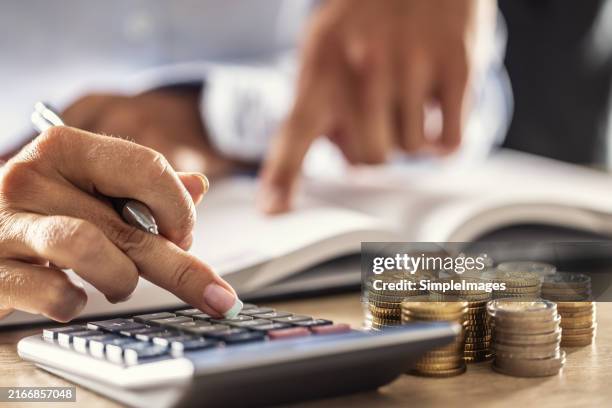 man and woman hand consider on calculator expenses of family budget against home background. lending purchase rental housing mortgage concept - skatt bildbanksfoton och bilder
