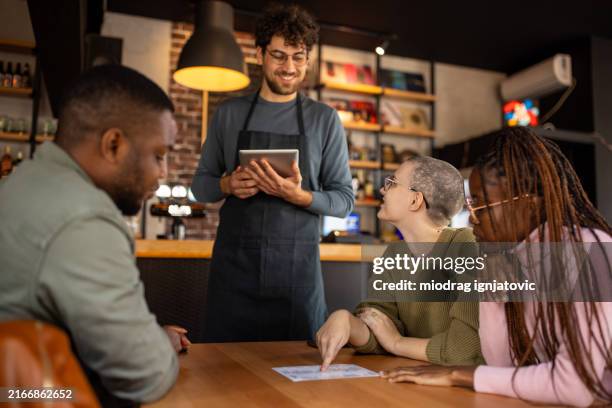 waiter taking orders from customers in a pub - ordering stock pictures, royalty-free photos & images