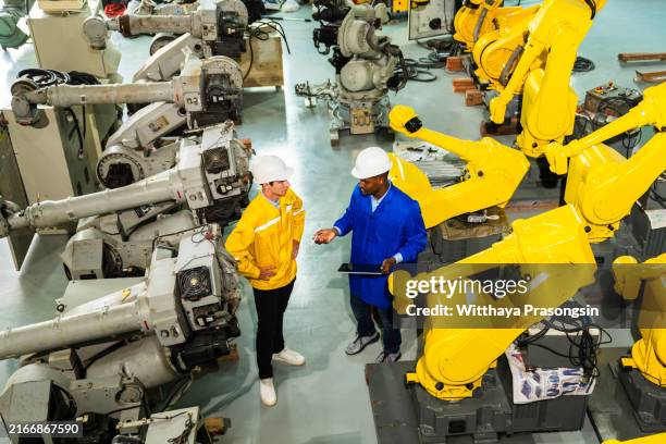 two engineers work on a robotic automation system. - system implementation stock pictures, royalty-free photos & images