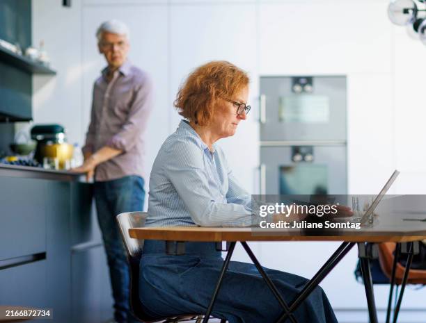 Symbolic photo. A man stands in the kitchen and washes dishes on August 13, 2024 in Berlin, Germany.