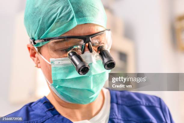 female surgeon with special magnifying glasses - micro surgery stock pictures, royalty-free photos & images