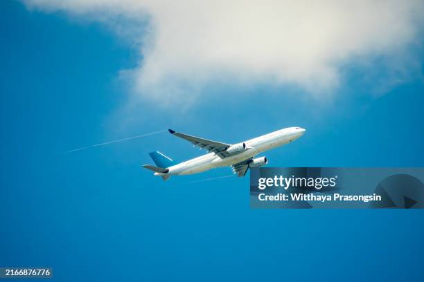 passenger jet airplane over clouds - commercial jet stock pictures, royalty-free photos & images