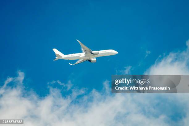 commercial airline flying on blue sky - schweben stock-fotos und bilder