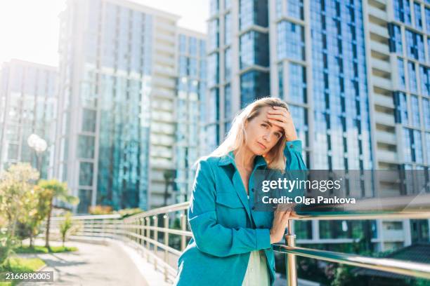 concerned woman on the street of the city - 40 44 years stock pictures, royalty-free photos & images