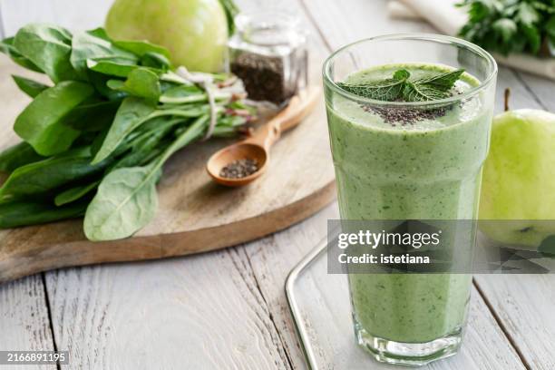 green smoothie with fresh leaf vegetables, fruits, herbs, and chia seeds - smoothie bildbanksfoton och bilder