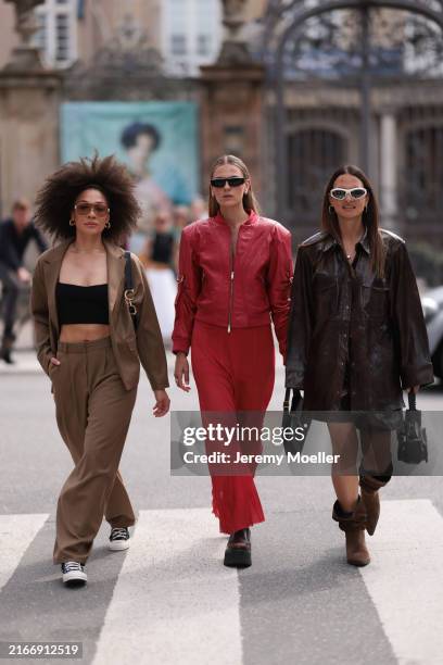 Julia Dalia is seen wearing a brown hairband, large aviator sunglasses with golden metal frame and brown lenses, chunky golden hoop earrings, a fine...
