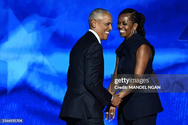 Former US President Barack Obama arrives onstage after his wife and former First Lady Michelle Obama introduced him on the second day of the...