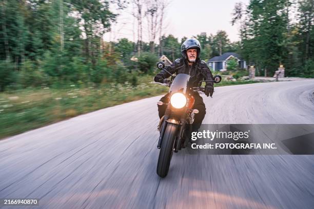 mature man riding his motorbike in the countryside at dawn - motorcycle biker stock pictures, royalty-free photos & images