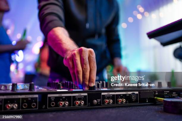 close up group of man and woman dancing with dj mixing music on console. young teenager friends having fun with dj mixing and scratching music mixer controller at house party with neon light. - dj stockfoto's en -beelden