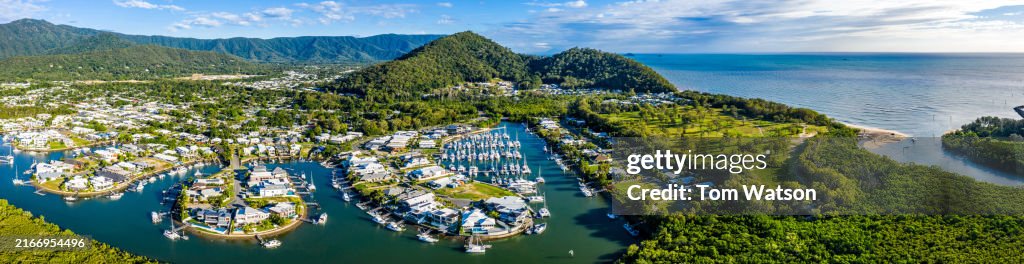 Panoramic Aerial view of a Cairns Marina showcasing boats and lush landscapes in bright daylight