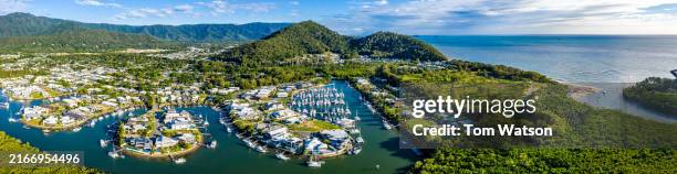 panoramic aerial view of a cairns marina showcasing boats and lush landscapes in bright daylight - cairns australië stockfoto's en -beelden