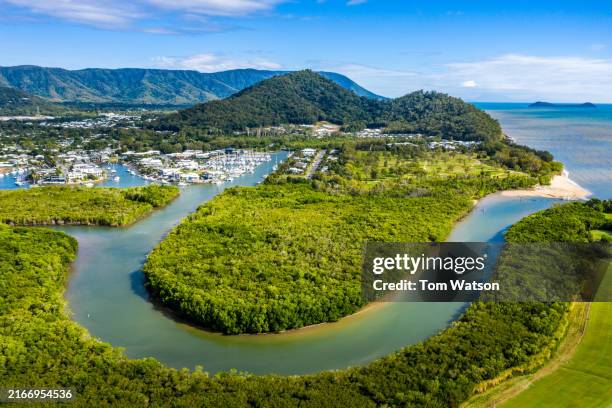 aerial view of a cairns marina with lush greenery and calm waters under a clear blue sky - cairns australië stockfoto's en -beelden