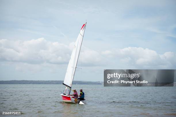 senior man and senior woman boat sailing race - sailing stock pictures, royalty-free photos & images