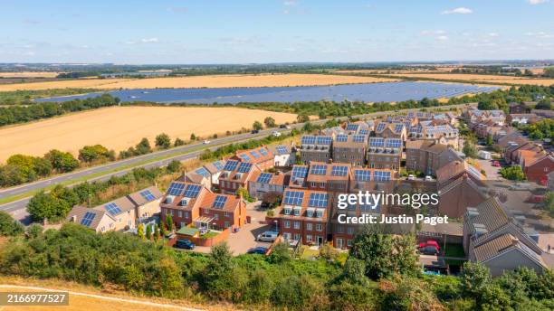 a drone/earial view of a housing development with solar panels - sustainable living - solar energy stock pictures, royalty-free photos & images