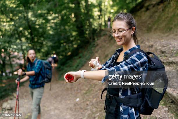 applying insect repellent to arm in the forest - backpack sprayer stock pictures, royalty-free photos & images