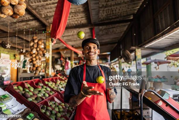 retrato de un vendedor lanzando limón al aire en un mercado callejero - vendedor del mercado fotografías e imágenes de stock